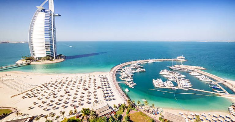 Dubai, United Arab Emirates - December 10, 2014: The Burj Al Arab Hotel, left side on the beach near Madinat Jumeriah Resort. The Burj Al Arab is a luxury hotel located in Dubai, United Arab Emirates. At 321 m (1,053 ft), it is the fourth tallest hotel in the world. The Burj Al Arab stands on an artificial island 280 m (920 ft) out from Jumeirah beach, and is connected to the mainland by a private curving bridge. It is an iconic structure whose shape mimics the sail of a ship.